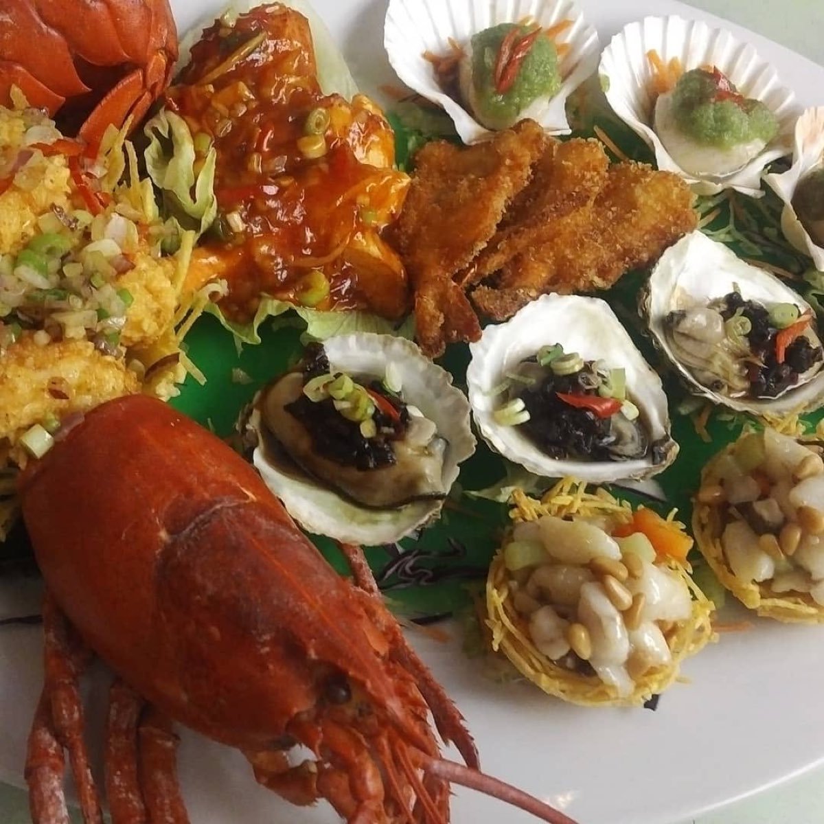 Grote zeevruchtenschotel met kreeft, oesters en sint-jakobsschelpen
